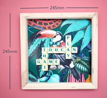 Load image into Gallery viewer, Characterful and colourful scrabble art with a rainforest design background and 'Toucan Play That Game' written in vintage scrabble tiles presented in a natural wooden box frame