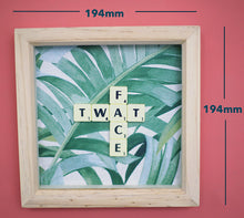 Load image into Gallery viewer, Framed wall art collage with Tropical leaf background and "twat face" written in scrabble tiles
