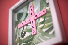 Load image into Gallery viewer, Characterful and colourful scrabble art with a green tropical leaf paper background and &#39;Fabulous Darling&#39; written in pink vintage scrabble tiles presented in a white box frame 
