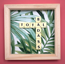 Load image into Gallery viewer, Framed wall art collage with Tropical leaf background and &quot;total badass&quot; written in scrabble tiles 
