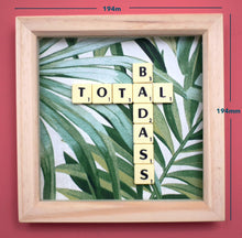 Load image into Gallery viewer, Framed wall art collage with Tropical leaf background and &quot;total badass&quot; written in scrabble tiles 
