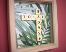 Load image into Gallery viewer, Framed wall art collage with Tropical leaf background and &quot;total badass&quot; written in scrabble tiles 
