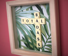 Load image into Gallery viewer, Framed wall art collage with Tropical leaf background and &quot;total badass&quot; written in scrabble tiles 
