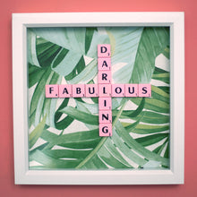 Load image into Gallery viewer, Characterful and colourful scrabble art with a green tropical leaf paper background and &#39;Fabulous Darling&#39; written in pink vintage scrabble tiles presented in a white box frame 
