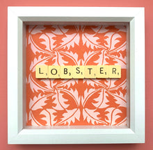 Load image into Gallery viewer, Characterful and colourful scrabble art with red patterned paper background and &#39;Lobster&#39; written in vintage scrabble tiles presented in a white box frame 
