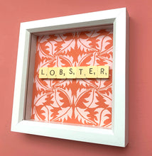 Load image into Gallery viewer, Characterful and colourful scrabble art red patterned background with &#39;Lobster&#39; written in vintage scrabble tiles presented in a white box frame 
